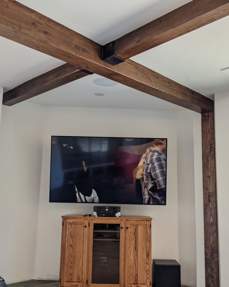 In-ceiling loudspeakers trimmed flush into a white ceiling with exposed timber beams